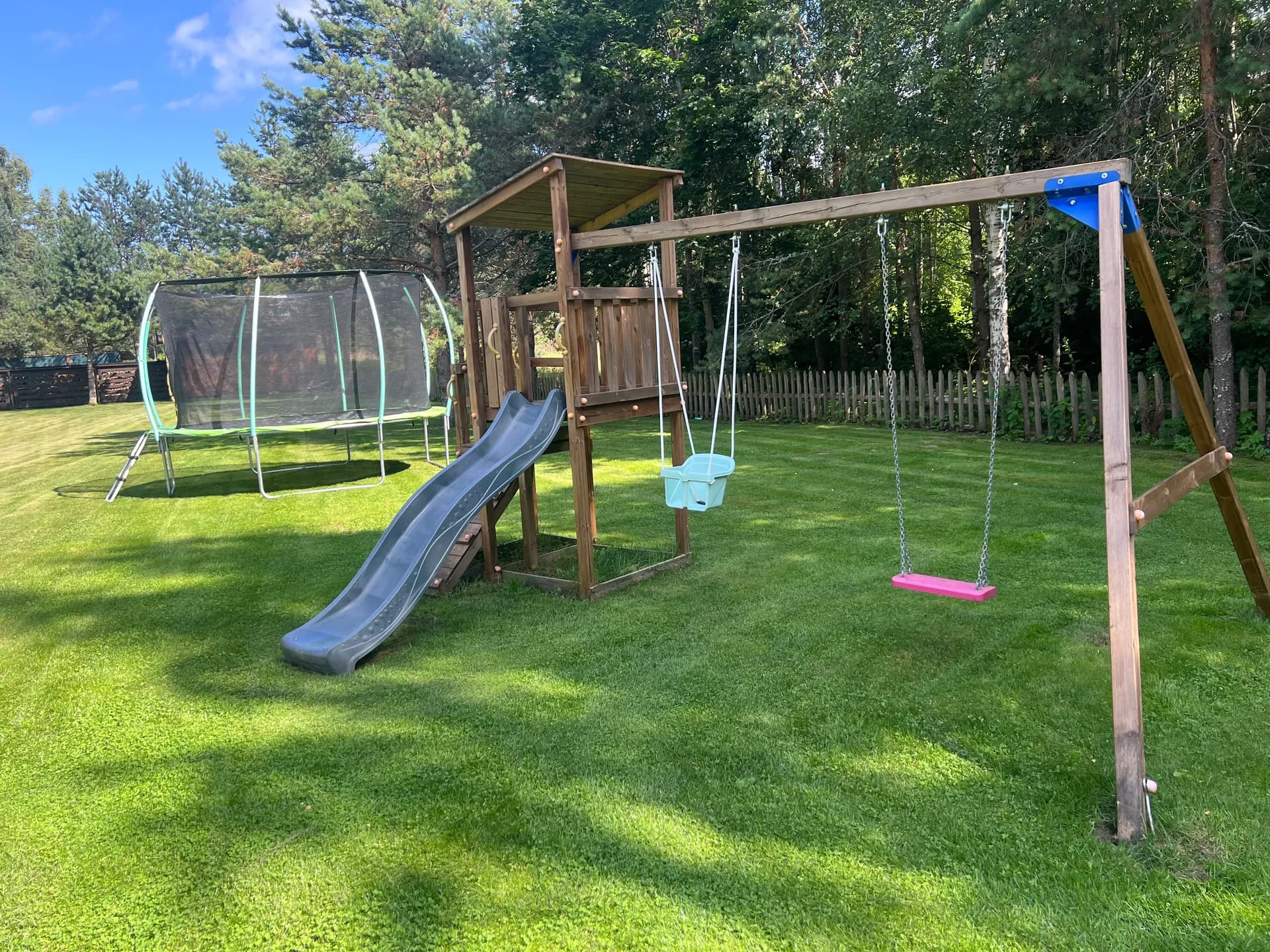 Playground with trampoline, slide, and swings