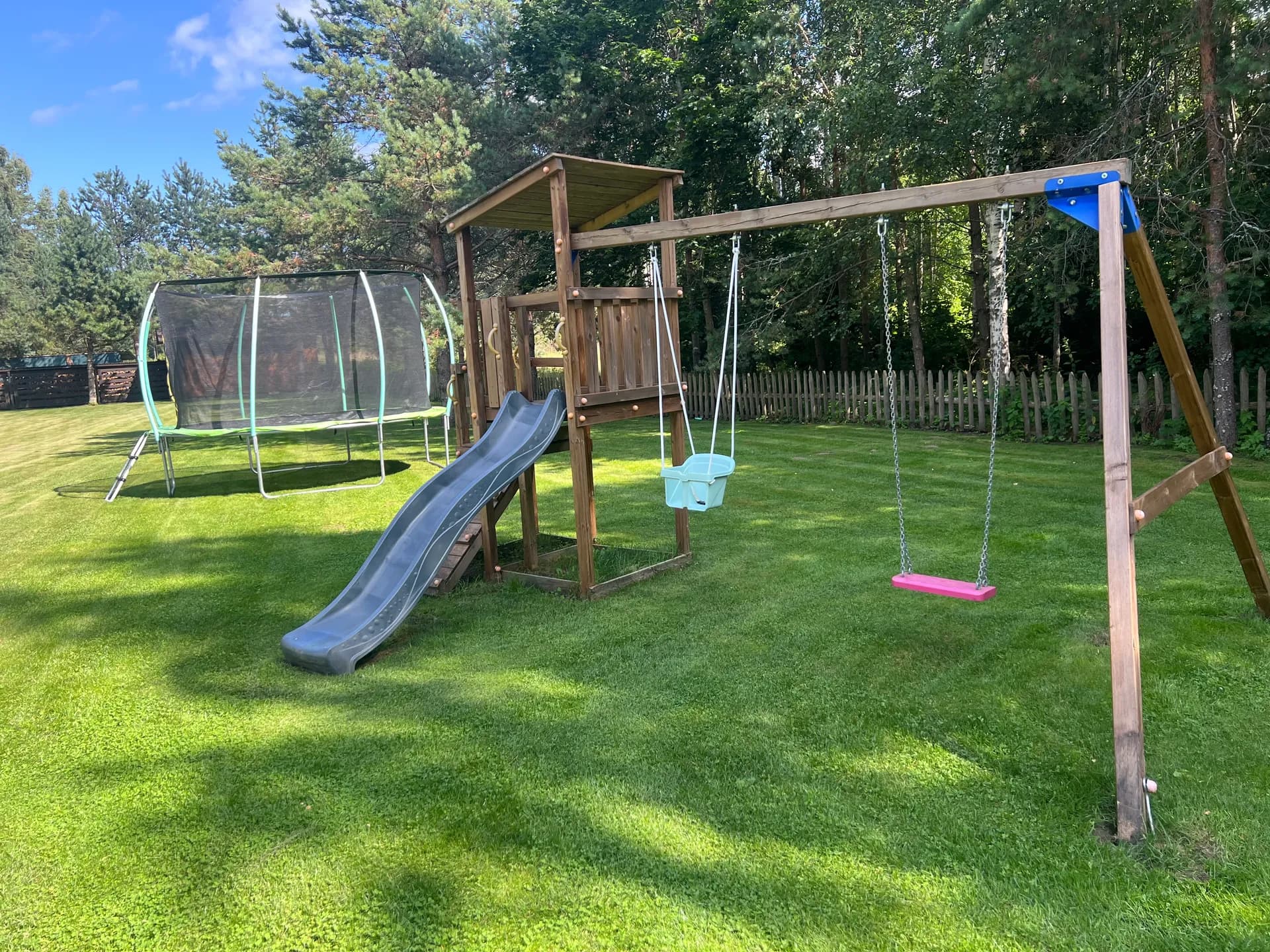 Large yard with a trampoline, swings, and slide